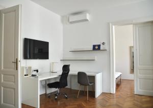 Cette chambre blanche dispose d'un bureau et de deux chaises. dans l'établissement Apartment Trdinova, à Ljubljana