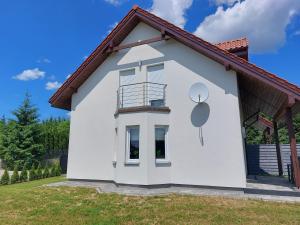 a white house with a round window on it at Holiday Home Mierki 2 in Olsztynek