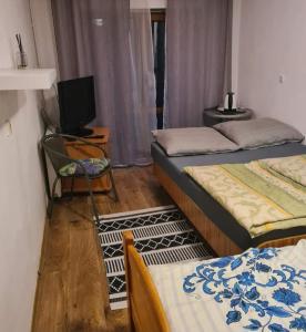 a room with three beds and a tv and a chair at Wczasy przy Młyńskiej 18 in Sarbinowo