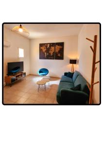 a living room with a green couch and a tv at Appartement Roussillon in Roussillon