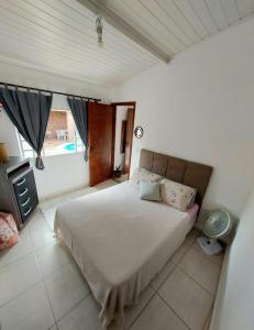 - une chambre avec un grand lit et une fenêtre dans l'établissement Casa Temporada Espaço Sara Piscina Aquecimento Solar, à São Lourenço