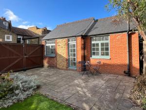 a brick house with a patio in the backyard at Forge Cottage - Pretty 1 Bedroom Cottage with Free Off Street Parking in London