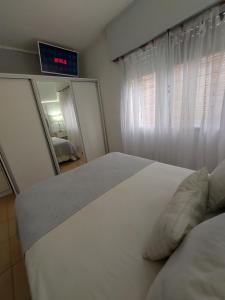 sypialnia z białym łóżkiem i lustrem w obiekcie Casa con piscina de uso exclusivo w mieście Gualeguaychú