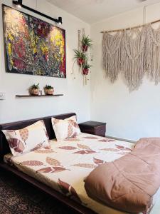 a bed in a bedroom with a painting on the wall at Anavrin Art House in New Delhi