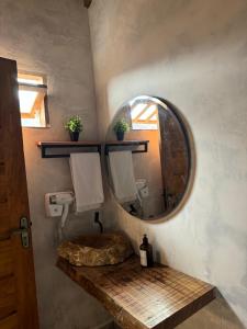 La salle de bains est pourvue d'un miroir rond et d'un lavabo. dans l'établissement Villa Joá - Suites, à Trancoso 29 autres photos