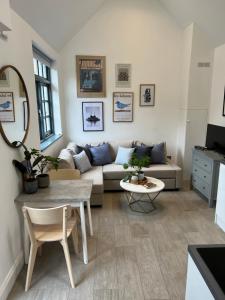 uma sala de estar com um sofá e uma mesa em Forge Cottage - Pretty 1 Bedroom Cottage with Free Off Street Parking em Londres