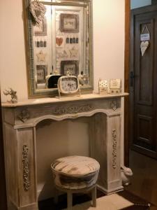 a mirror over a fireplace with a stool under it at Colle House in Rivisondoli