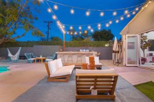 un patio con mesa, sillas y luces en Angel&Rose Universal Hollywood Heated Pool House King Bed, en Los Ángeles