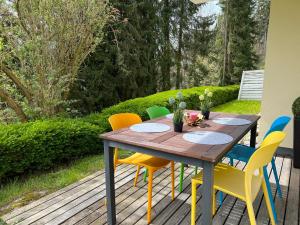 un tavolo in legno con sedie colorate su una terrazza di Schöne Ferienwohnung in Stockach a Stockach