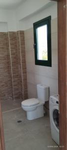 a bathroom with a toilet and a window at Villa Lemonia in Petra