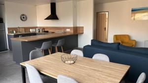 a living room with a table and a blue couch at Bel appartement à 200m de la plage in Barneville-Carteret