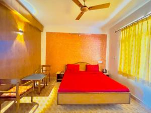 a bedroom with a red bed and a table at Grand view lodge and Restaurant Dharamshala - Partial Prepayment required to confirm booking in Dharamshala