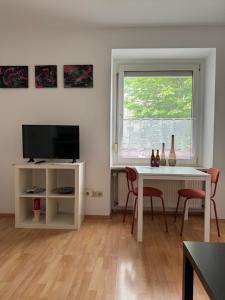 a living room with a white table and a television at 32m2 - gemütliche Wohnung in zentraler Lage in Hagen