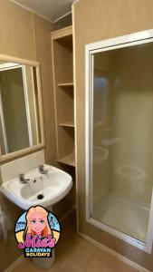 a bathroom with a sink and a shower at The Atlas Everglade Caravan in Ingoldmells