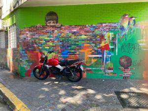 a motorcycle parked in front of a wall with a mural at Romántico apartamento en el corazón de Palermo. in Buenos Aires