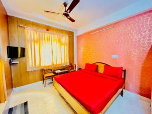 a bedroom with a red bed and a ceiling fan at Grand view lodge and Restaurant Dharamshala - Partial Prepayment required to confirm booking in Dharamshala