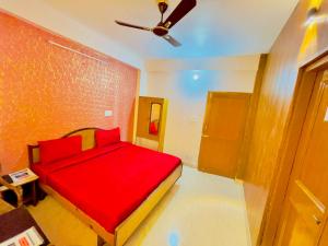 a bedroom with a red bed and a ceiling fan at Grand view lodge and Restaurant Dharamshala - Partial Prepayment required to confirm booking in Dharamshala