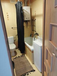 a bathroom with a tub and a toilet and a sink at Apartament Kajki in Mrągowo