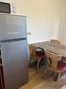 uma cozinha com uma mesa e um frigorífico em Othman Appartements Alte Schmiede 2 OG L em Hanôver