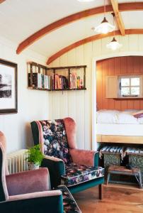 a living room with a couch and a bed at The Garden Hut Cilcain in Mold