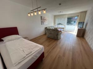 um quarto com uma cama e uma sala de estar em Othman Appartements Alte Schmiede 2 OG L em Hanôver