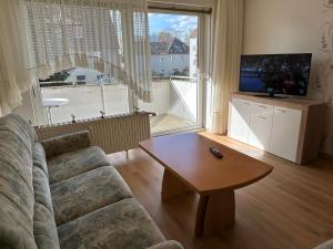 sala de estar con sofá, mesa y ventana grande en Othman Appartements Alte Schmiede 2 OG L en Hannover