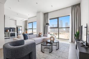 ein Wohnzimmer mit einem Sofa und einem TV in der Unterkunft Silkhaus Luxurious 1BDR with Beach Access and City View in Abu Dhabi