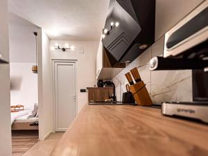 un soggiorno con pavimento in legno e una camera da letto di High Tide Apartment a Zara (Zadar)