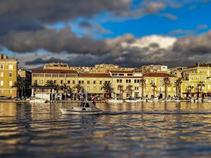 una piccola barca in acqua di fronte a una città di High Tide Apartment a Zara (Zadar)
