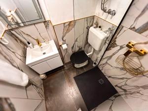 vista sul soffitto di un bagno con lavandino e servizi igienici di High Tide Apartment a Zara (Zadar) Altre 18 foto