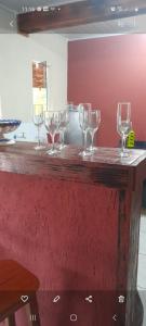 a bar with wine glasses on a wooden counter at Casa girassol in Nova Friburgo