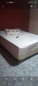 Casa girassol في نوفا فريبورغو: سرير مع مرتبة بيضاء عليها ورد