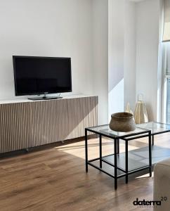 uma sala de estar com uma televisão e uma mesa de vidro em DATERRA 20 em Póvoa do Caraminhal