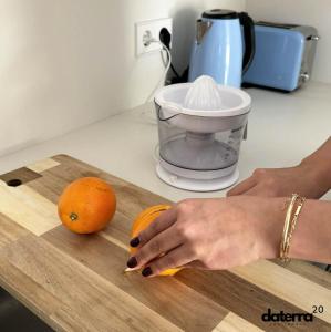 a woman is cutting an orange on a cutting board at DATERRA 20 in Pobra do Caramiñal