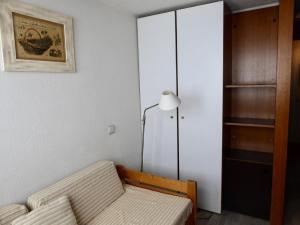 Résidence Palafour - Studio pour 2 Personnes 311 في تينيِ: غرفة معيشة مع أريكة ومصباح