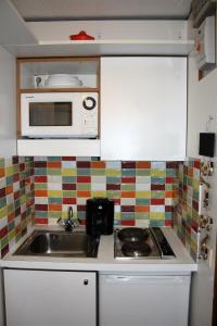 a kitchen with a sink and a microwave at Résidence Palafour - Studio pour 2 Personnes 311 in Tignes