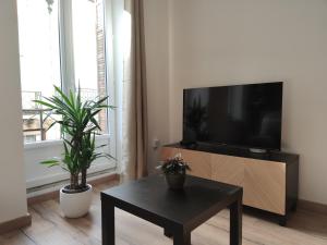 L'escale des vignobles في جيفري شامبرتان: غرفة معيشة مع تلفزيون وطاولة قهوة