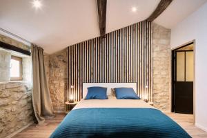 een slaapkamer met een groot bed met blauwe kussens bij Gîte au cœur des vignes in Montagne