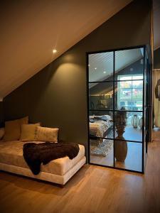 um quarto com uma cama e um espelho grande em Mysig lägenhet med öppen planlösning på hästgård. em Ljung