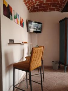 una sedia in una stanza con TV a parete di Podere Valle Pozzo a Canale