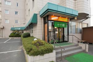een winkel voor een gebouw met een bord erop bij Green Hotel Kitakami in Kitakami