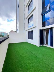 a building with a green lawn in front of it at Melodious homes elite residency in Nairobi