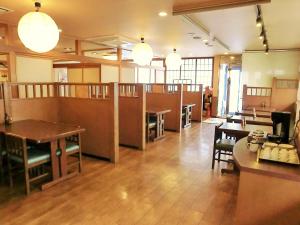 a dining room with tables and chairs and lights at Green Hotel Kitakami in Kitakami