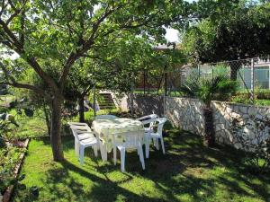 une table et des chaises sous un arbre dans une cour dans l'établissement Ferienwohnung für 4 Personen ca 58 qm in Banjole, Istrien Istrische Riviera, à Banjole