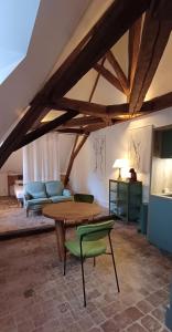 a room with a table and chairs and a bed at Logis La Vachère in Avallon