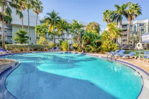 a large swimming pool with palm trees and a building at La Brisa Unit 105 North Building in Key West