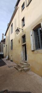 a building with a door and stairs in front of it at Logis La Vachère in Avallon