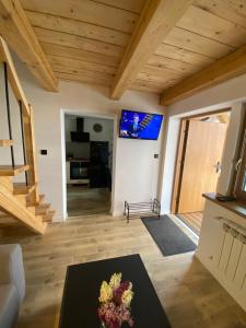 een woonkamer met houten plafonds en een televisie bij Apartament przy Browarze in Żywiec
