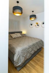 um quarto com uma cama com duas luzes e dois espelhos em Bubbly Apartment em Bled