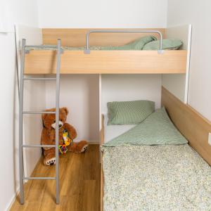 um pequeno quarto com beliches e um urso de peluche em Bubbly Apartment em Bled